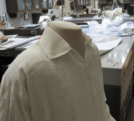 White historical shirt mounted on a mannequin in a conservation lab.